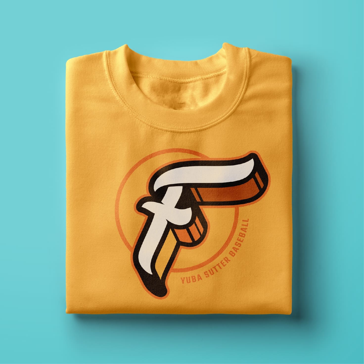 A folded yellow T-shirt featuring a bold, stylized letter F in white, black, and orange, with the text Yuba Sutter Baseball curved below the design, placed on a light blue background.